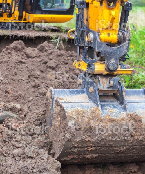 Yellow excavator on the gas pipeline performs excavation work